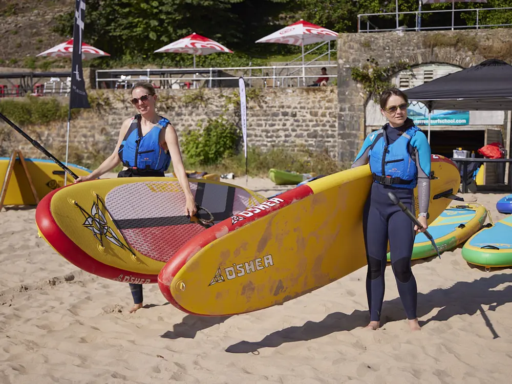 Women paddleboarding during a retreat in Wales