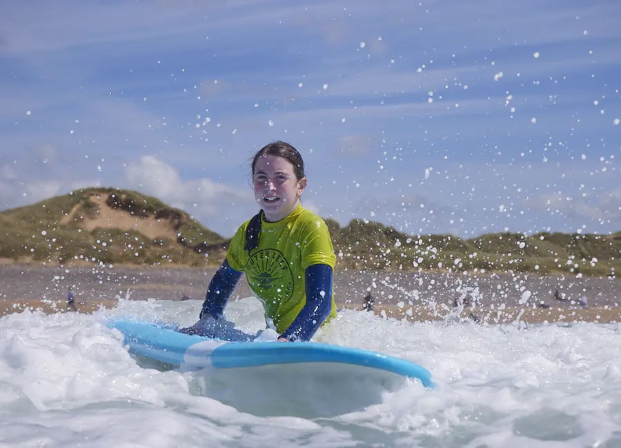 Surf camp camper riding a wave in Pembrokeshire