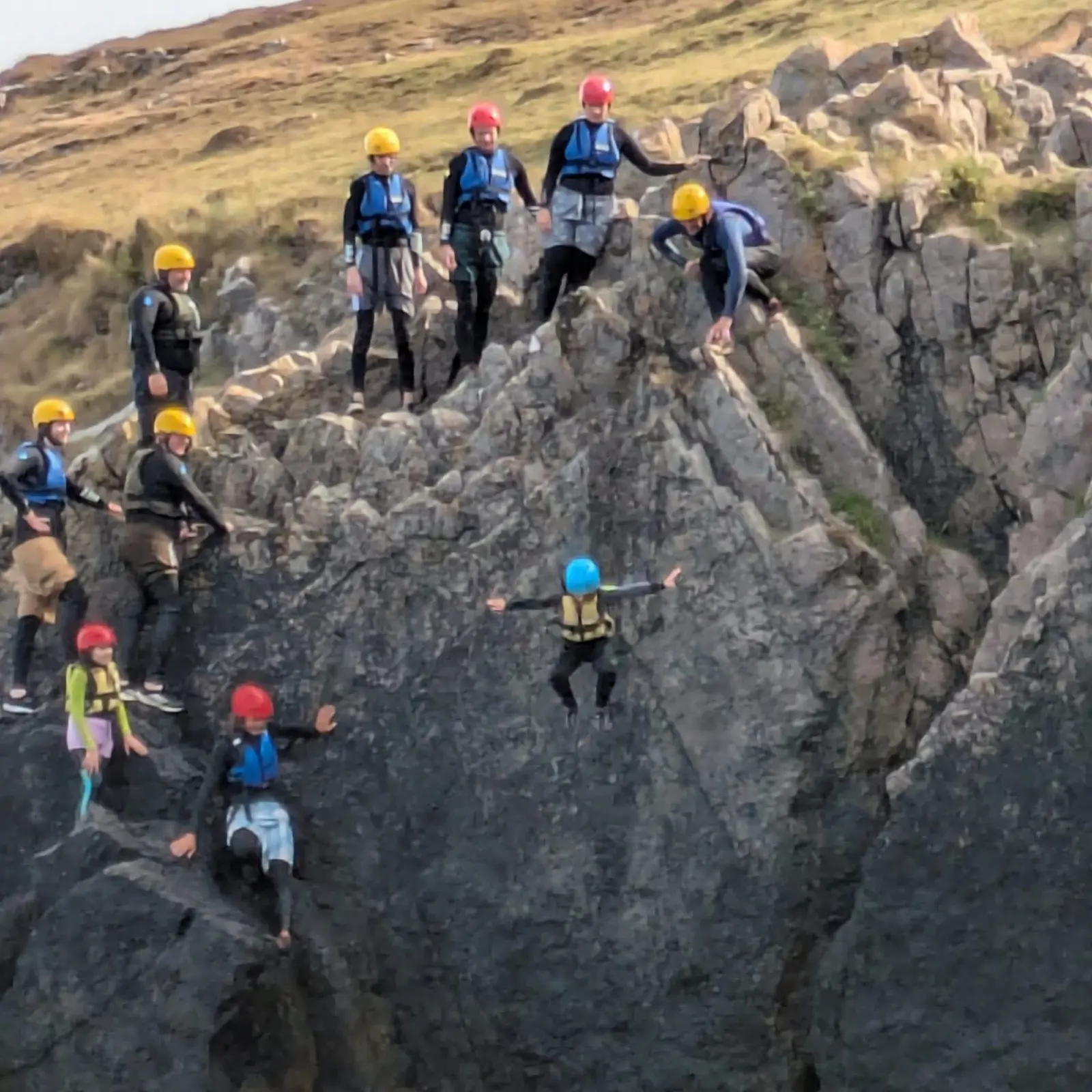 Coasteering group exploring natural coastal rock formations